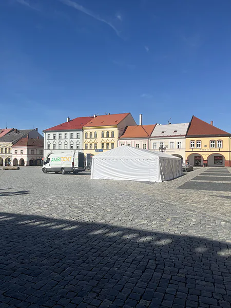Rozostavaný biely párty stan a dodávka Ambitent na námestí v Jičíne.