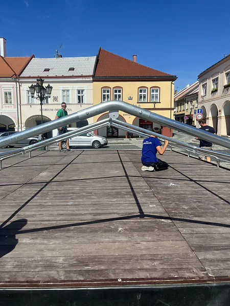 Montáž strešnej konštrukcie párty stanu na pódiu v Jičíne.